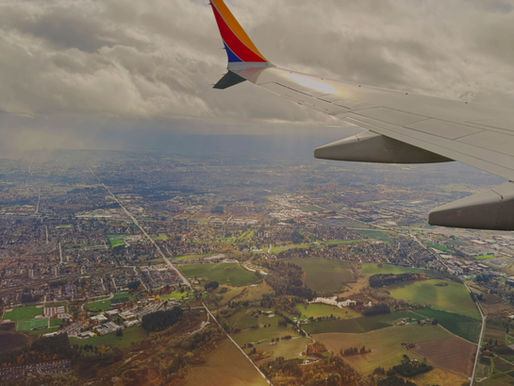 Aerial view from an airplane wing over fields and a city, symbolizing gaining perspective and returning after bipolar depression and ADHD.