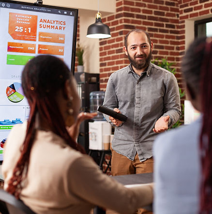 executive-manager-standing-beside-monitor-showing-marketing-graphs-explaining-company-stra