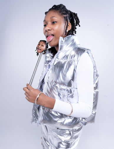 Person in silver vest with tongue out holding mini head prop