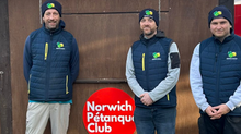 Tom Ralph, Gavin Seymour, and Jonathan Gracie in Onions uniform standing in front of the Norwich Petanque sign.
