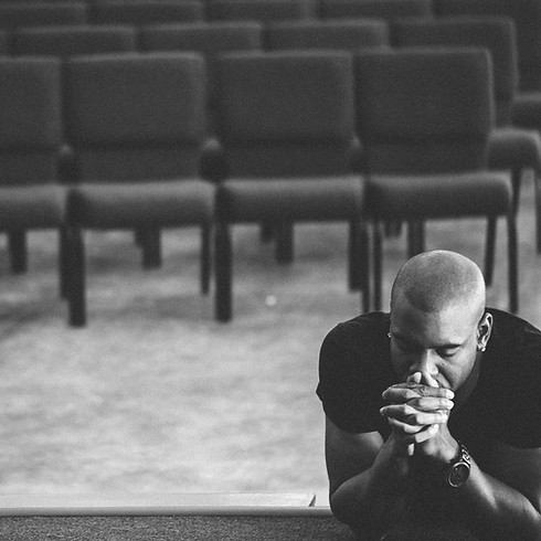 man_leaning_on_stage_with_eyes_closed_in_prayer-5616x3744.jpg