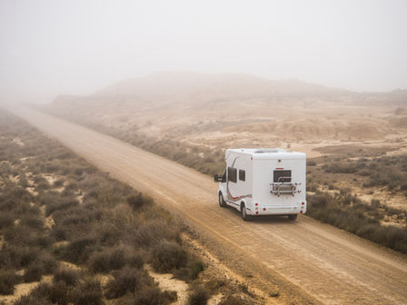 An RV drives through the desert