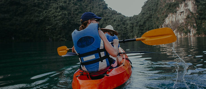 DOS PERSONAS CON CHALECOS SALVAVIDAS PRACTICANDO CANOTAJE 