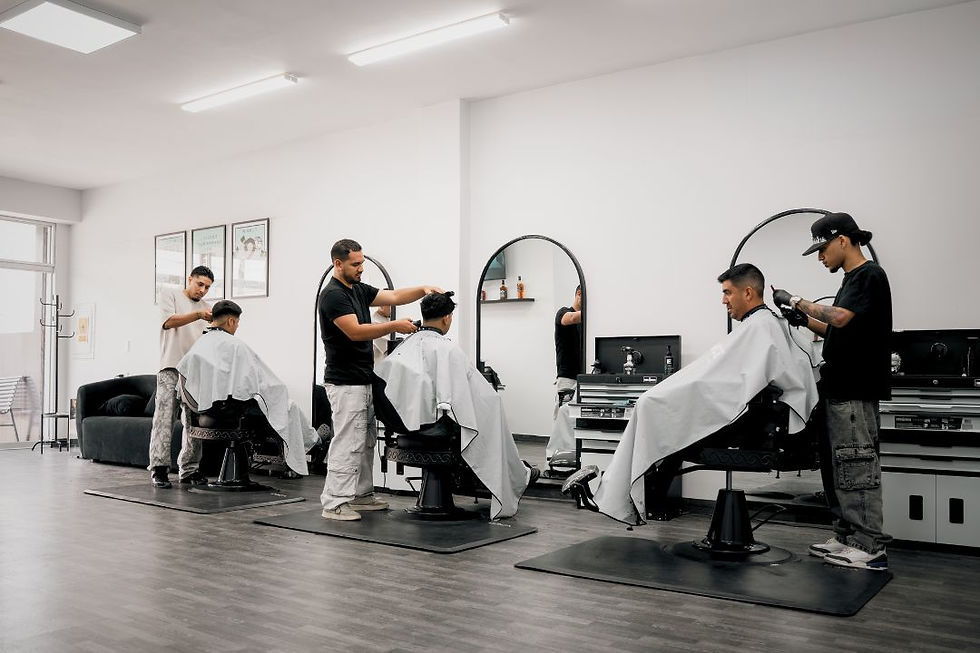 Equipo de barberos trabajando en el local principal de Fade Essence en San Miguel.