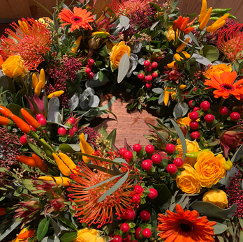 Couronne funéraire aux fleurs et piments orangés