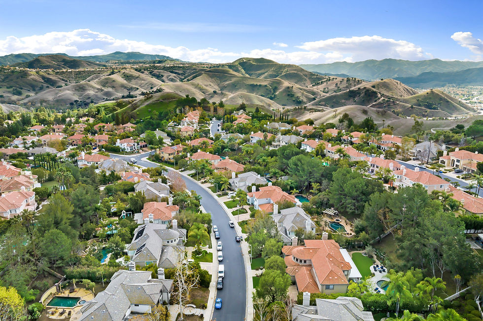 Aerial view of a suburban neighborhood with houses and hills