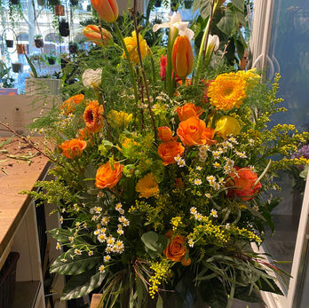 Grand arrangement floral orange et jaune, tulipes, roses, fleurs sauvages