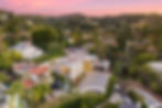 Modern house in a lush hillside neighborhood at sunset