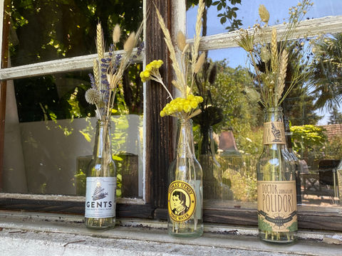 Trois bouteilles décorées de fleurs séchées, 'GENTS', 'Thomas Henry', 'Doctor John Polidori'