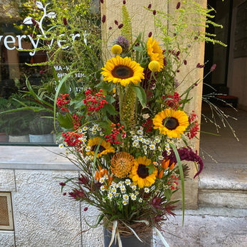 Grand arrangement floral Everyvert : tournesols, protea, et baies rouges