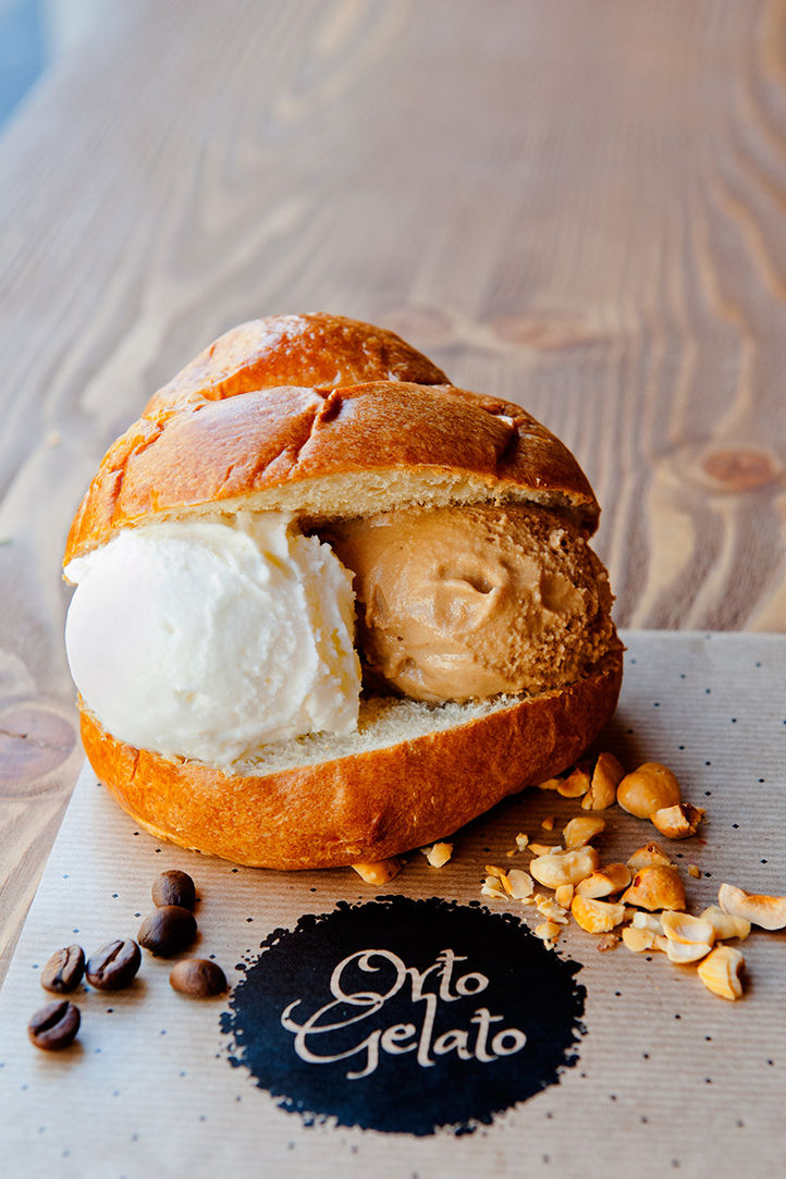 Gelato al gusto di vaniglia e caffè in un panino, con nocciole e chicchi di caffè sul tavolo, Orto Gelato