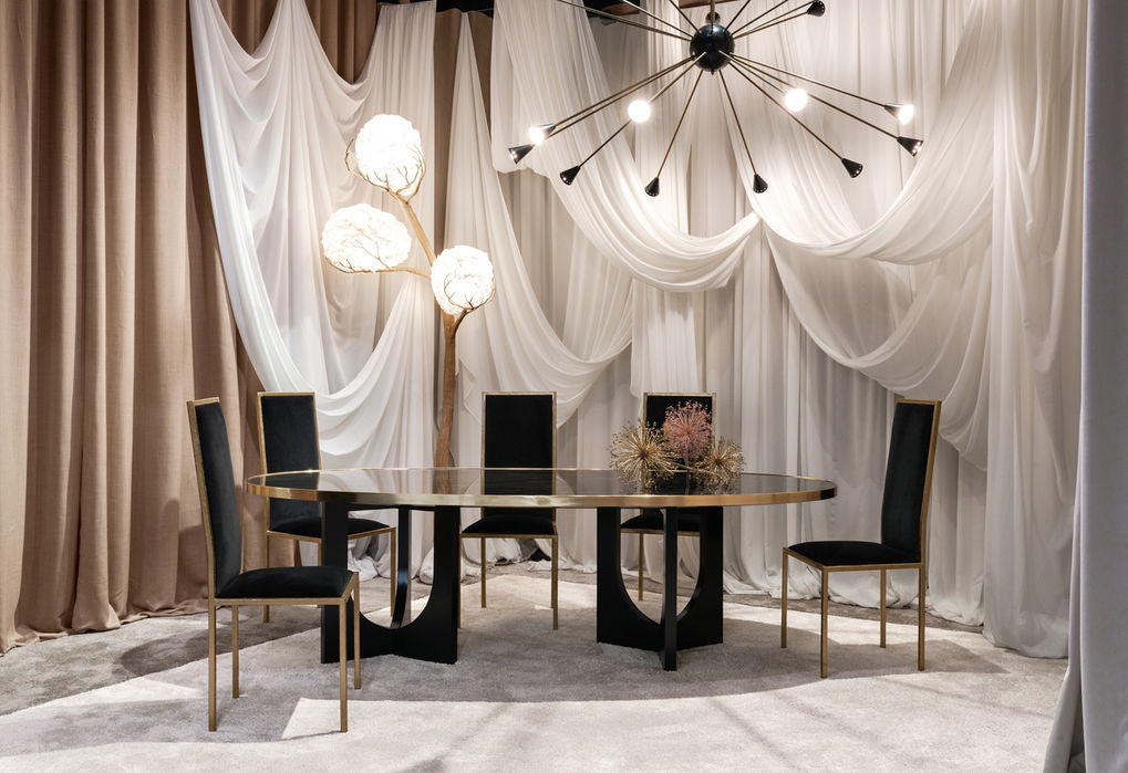 Dining table with an oval-shaped top in hand-painted glass in back with gold details and a brass edge. The base is made of hand painted wood.