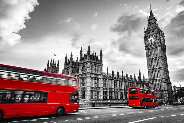London, the UK. Red buses in motion and Big Ben, the Palace of Westminster. The icons of E