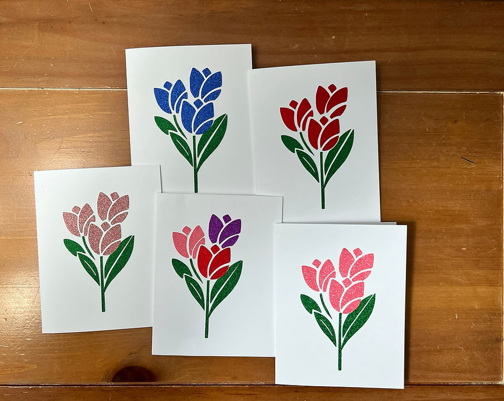 Five handmade tulip greeting cards in assorted colors displayed on a wooden table.