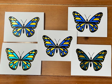 Five handmade butterfly greeting cards with layered black, blue, and yellow butterfly designs on white card fronts.