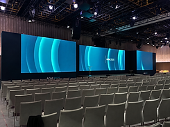 AGM 2025 conference stage with turquoise screens.png