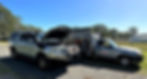 Toyota Hilux and Mazda BT50 parked on gravel driveway with green field and fence behind. The Hilux has just been serviced by a mechanic and has the bonnet up. The BT50 has a canopy with the doors open showing some of the tools used in the service. On the door of the BT50 is a sticker that says "Kashy. Find an honest mechanic.".