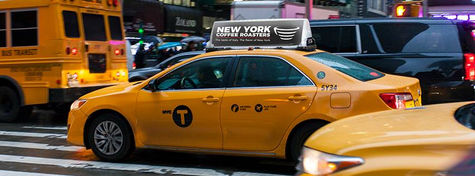 a yellow taxi cab with a sign on top that says new york coffee roasters .
