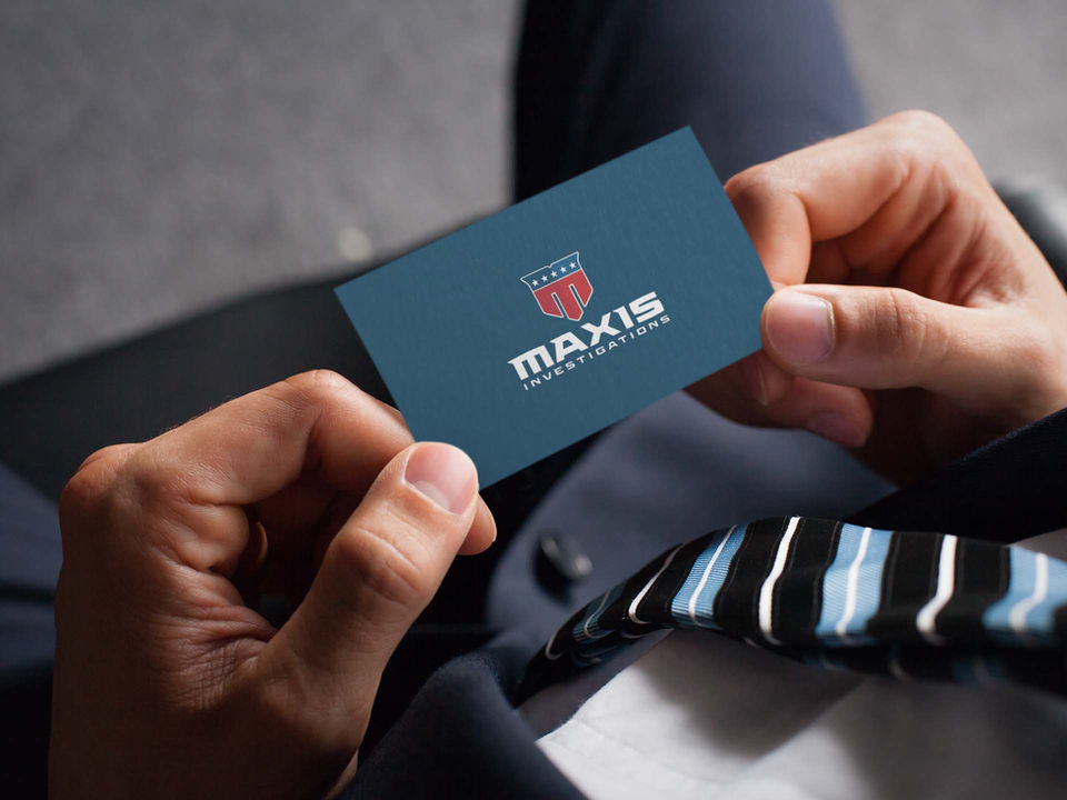 Business card design for Maxis Investigations featuring a modern shield logo