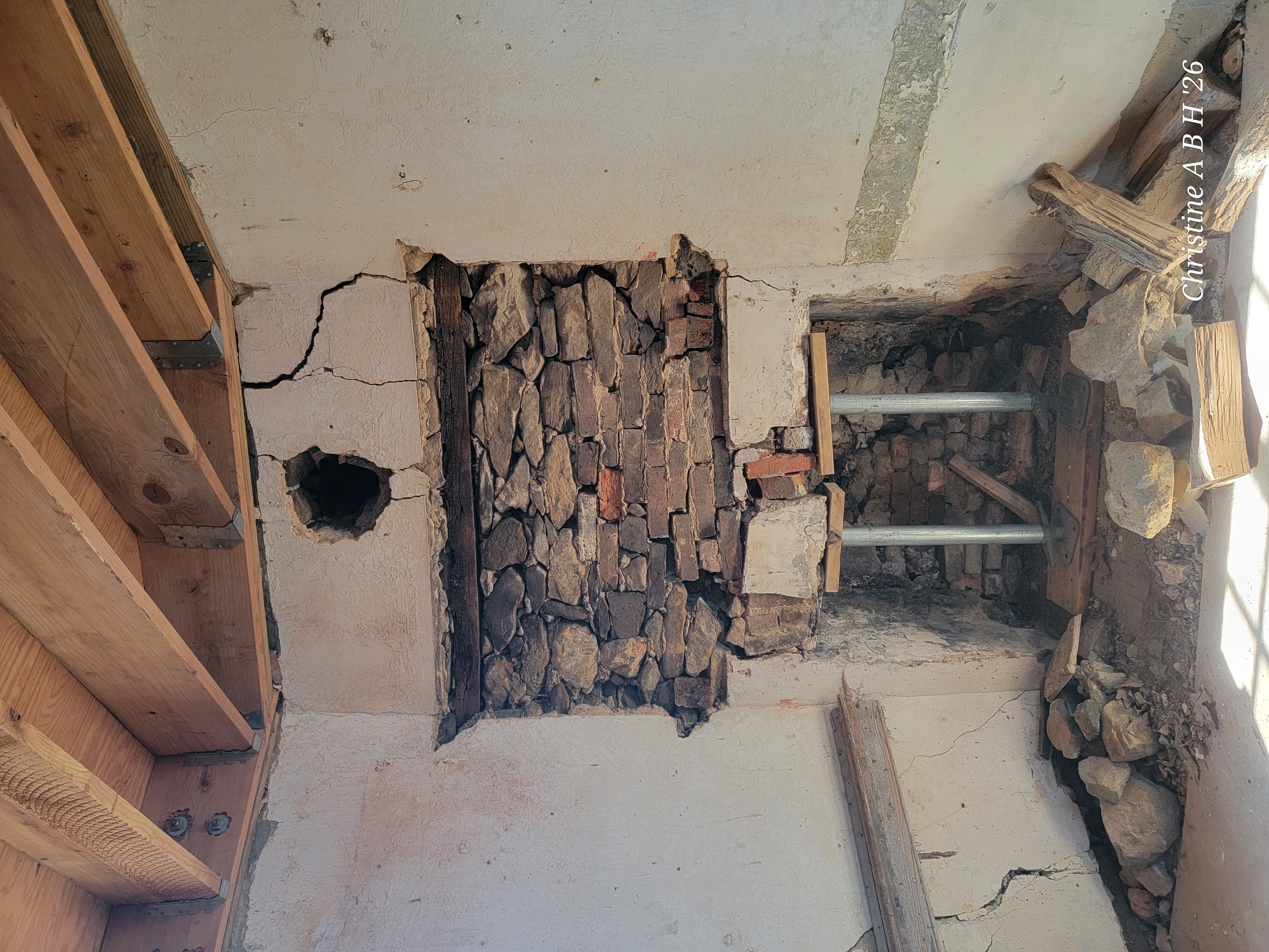 A close-up view of skilled masonry work being performed on the exterior of a historic stone house.
