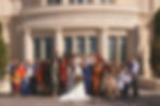 A large wedding group cheers outside and LDS temple