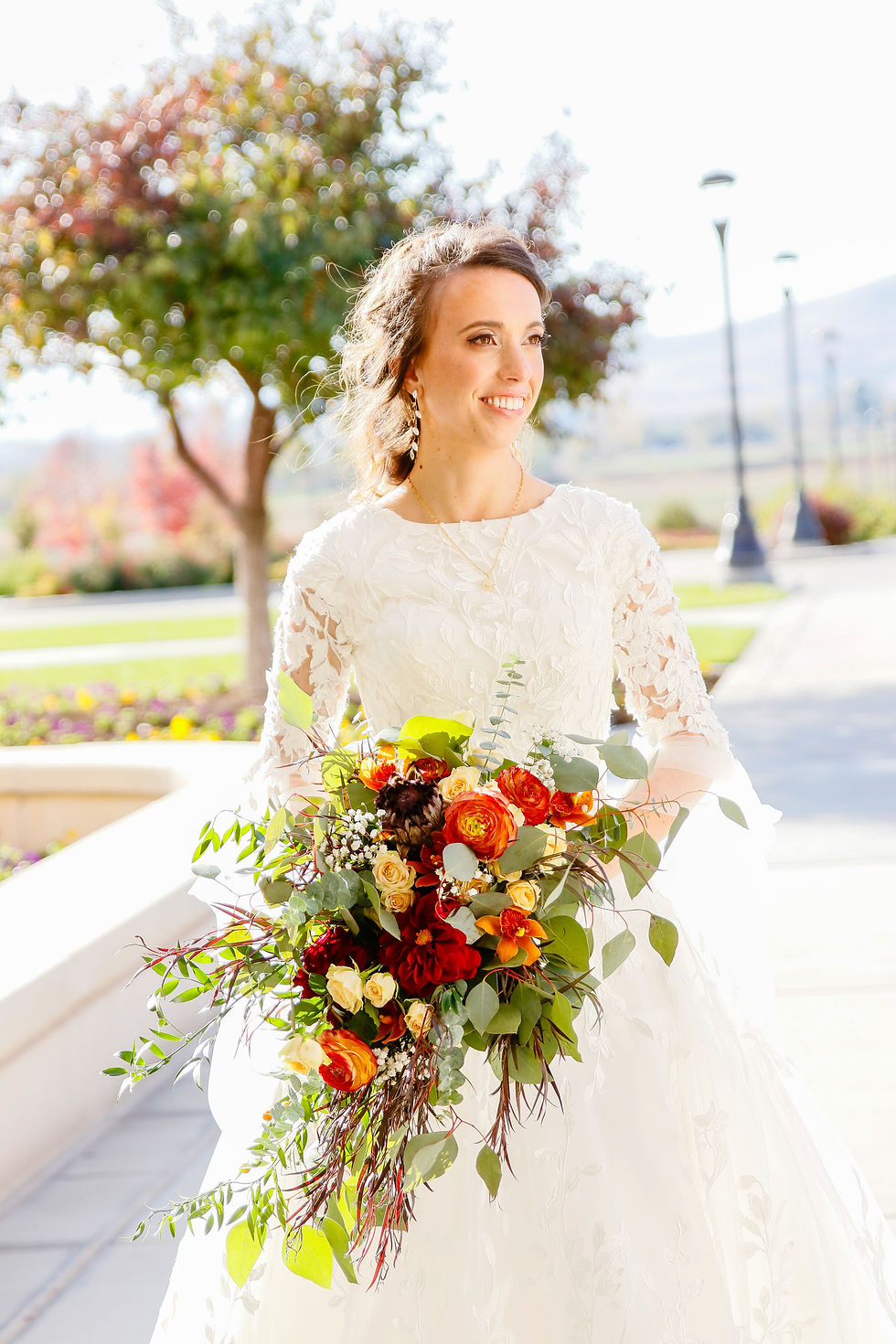 a bride poses for a picture while drenched in beautiful sunlight