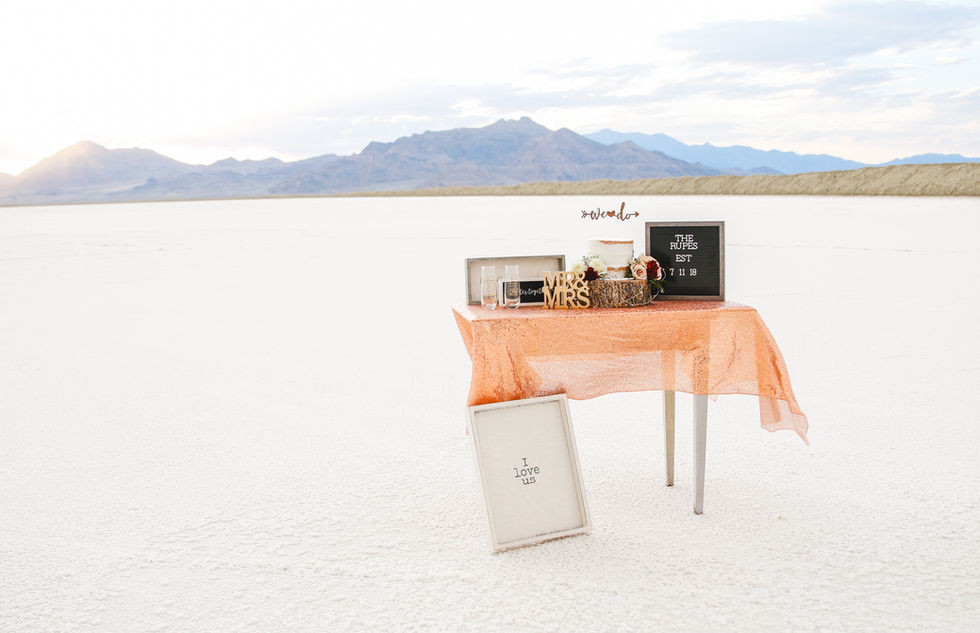 A table stands alone on the Bonneville Salt Flats decorated with wedding items.