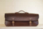 front view of a handmade leather tool bag with brass buckles