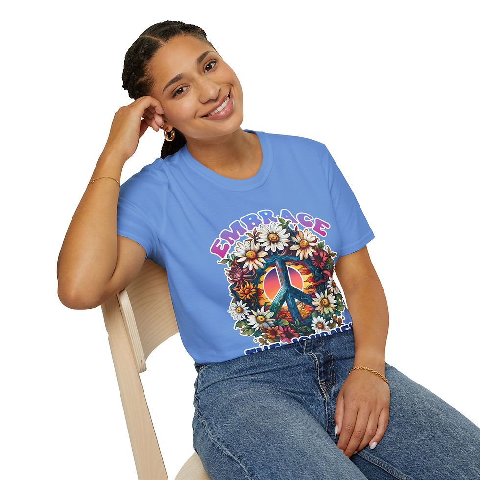 Smiling woman wearing blue Embrace peace sign top, sitting in chair.