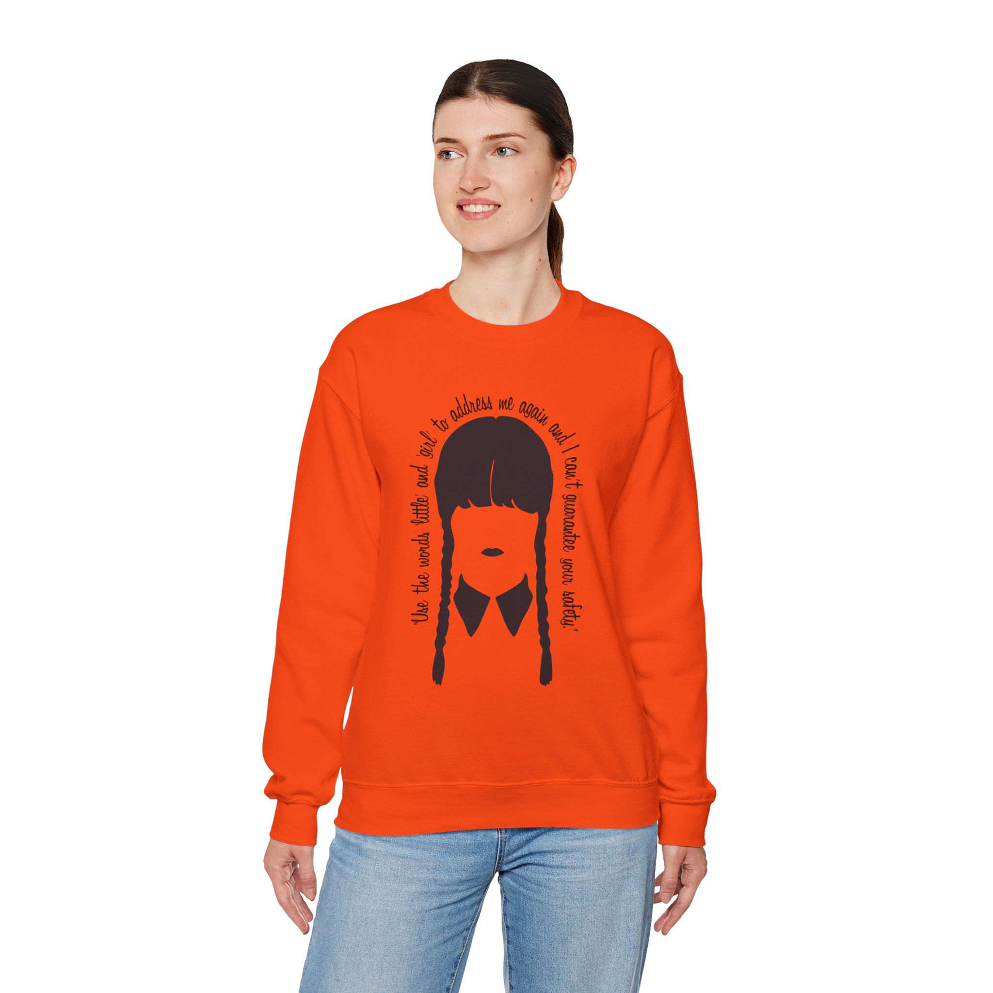 Woman wearing orange sweatshirt with Wednesday Addams graphic and quote.
