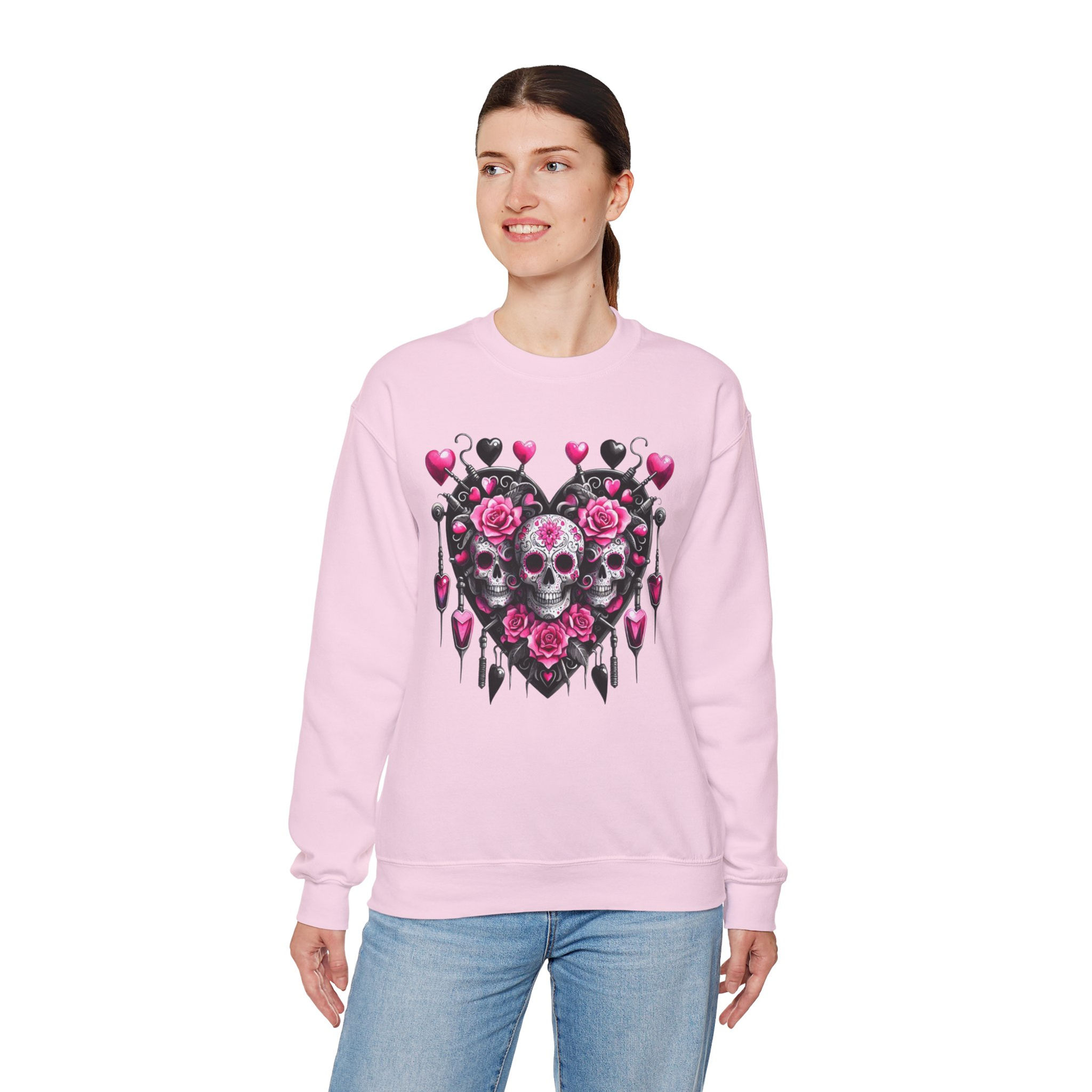 Woman wearing pink sweatshirt with skull heart graphic design smiling.