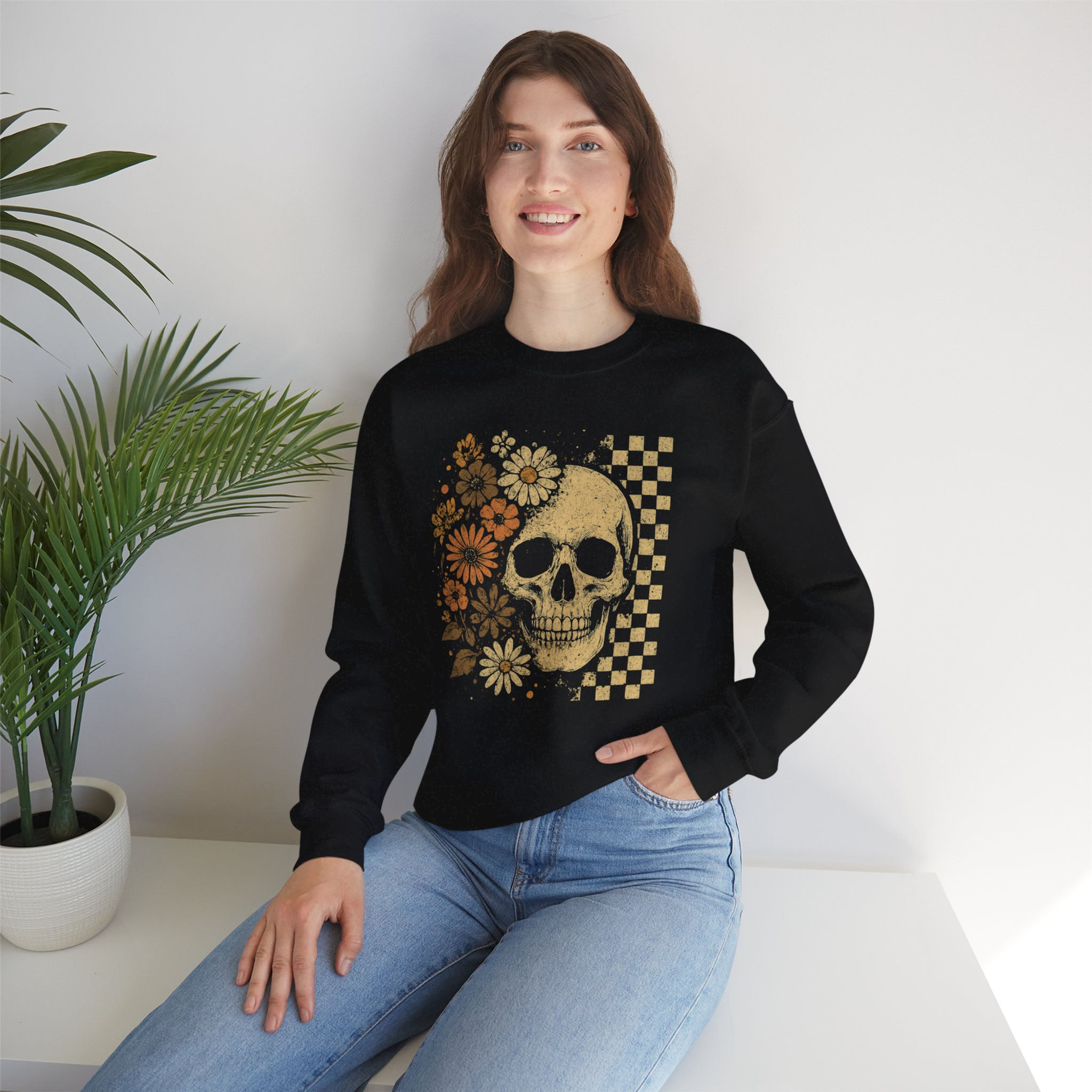 Woman wearing black sweatshirt with skull and floral design smiles. Cozy look.