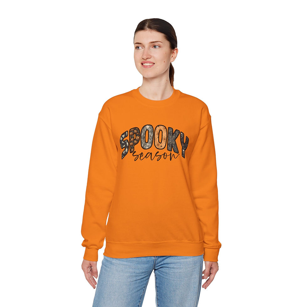 Thumbnail: Woman wearing orange sweatshirt with the text "Spooky Season" and smiling.