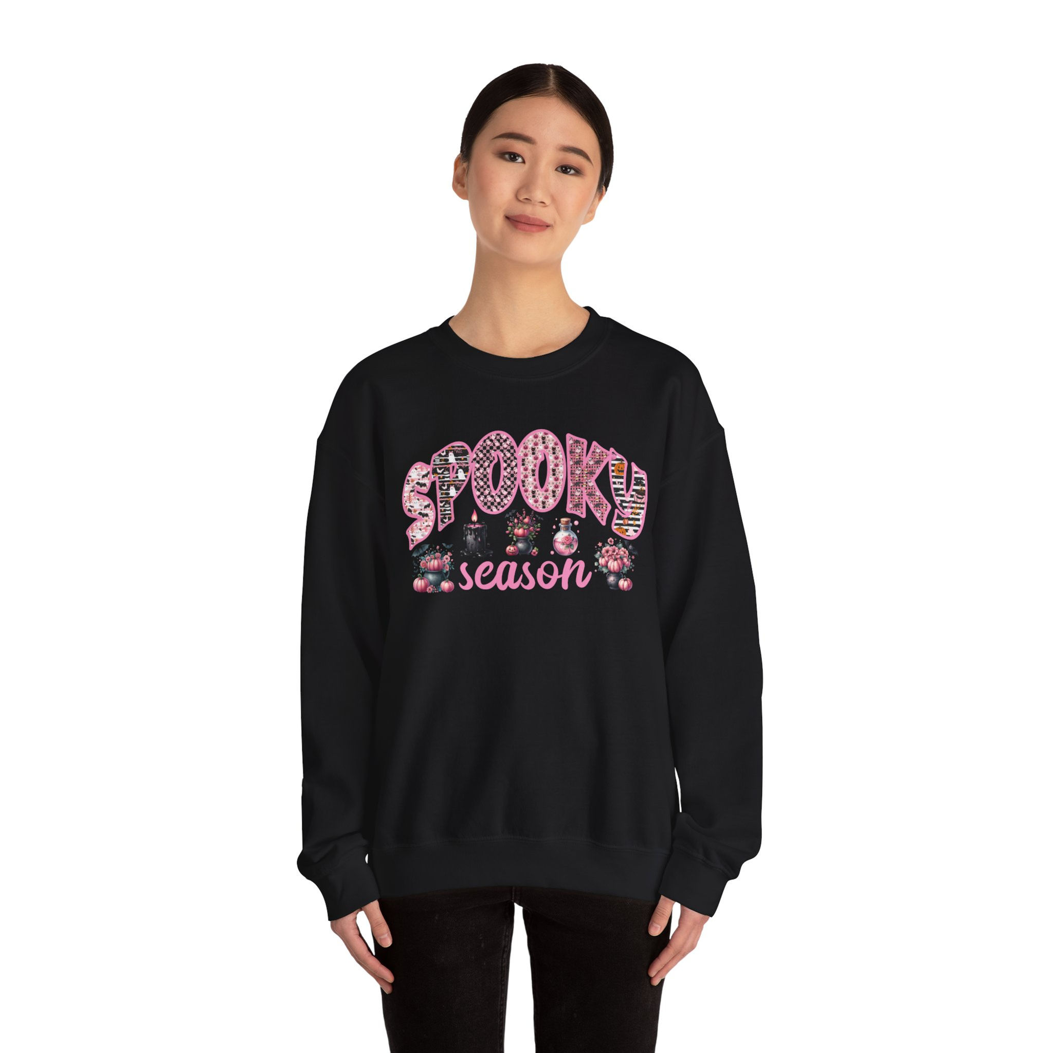Young woman wearing black sweatshirt with the text Spooky season graphic.