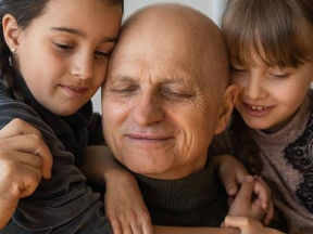 Man embracing his daughters