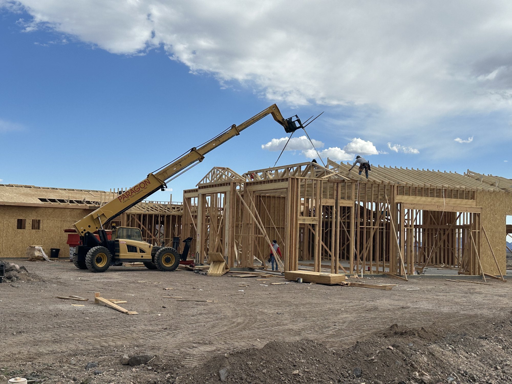 Paragon framing crew setting engineered roof trusses with telescopic handler