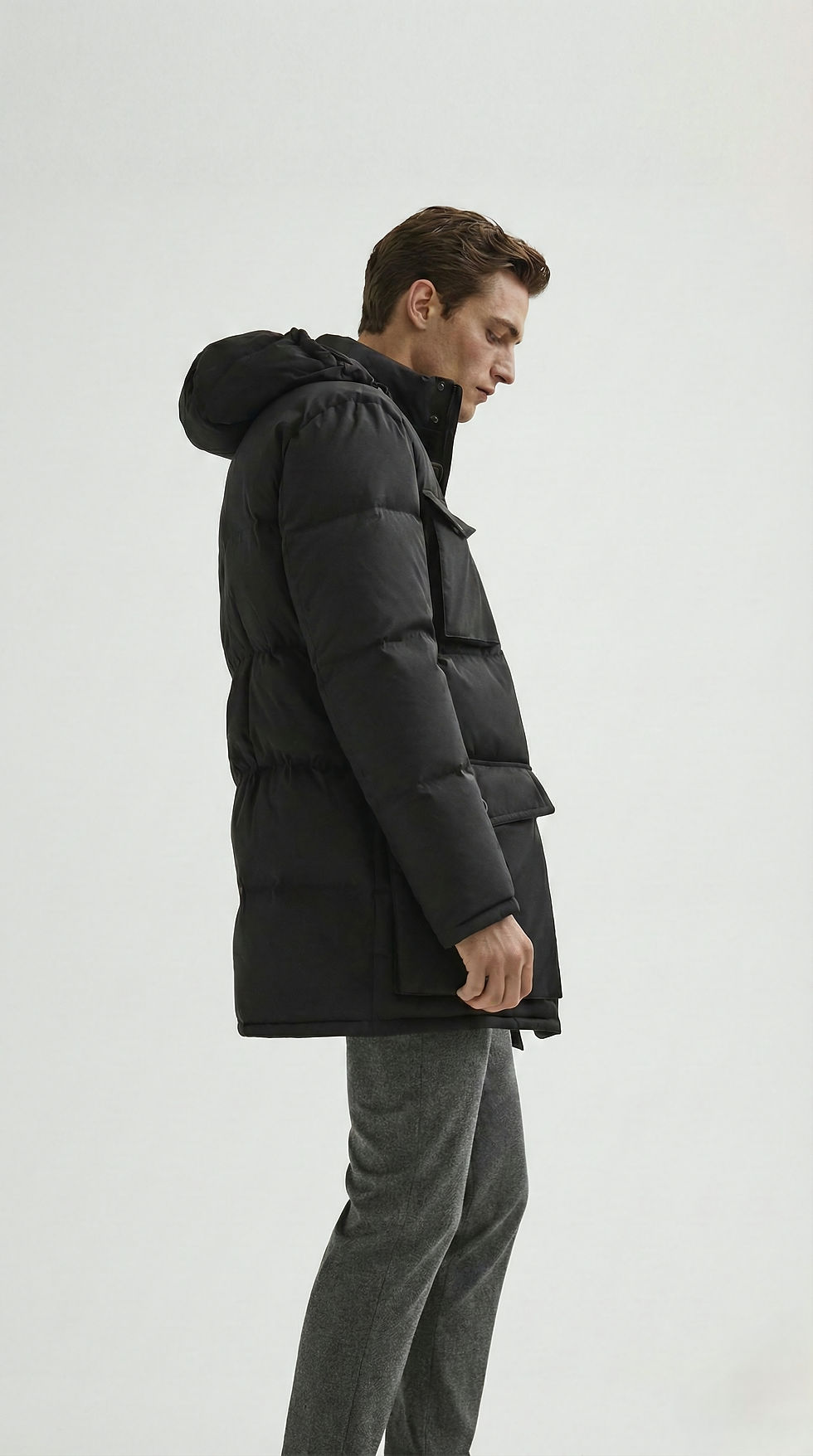Man wearing black winter coat with a hood and pockets. Cold weather gear.