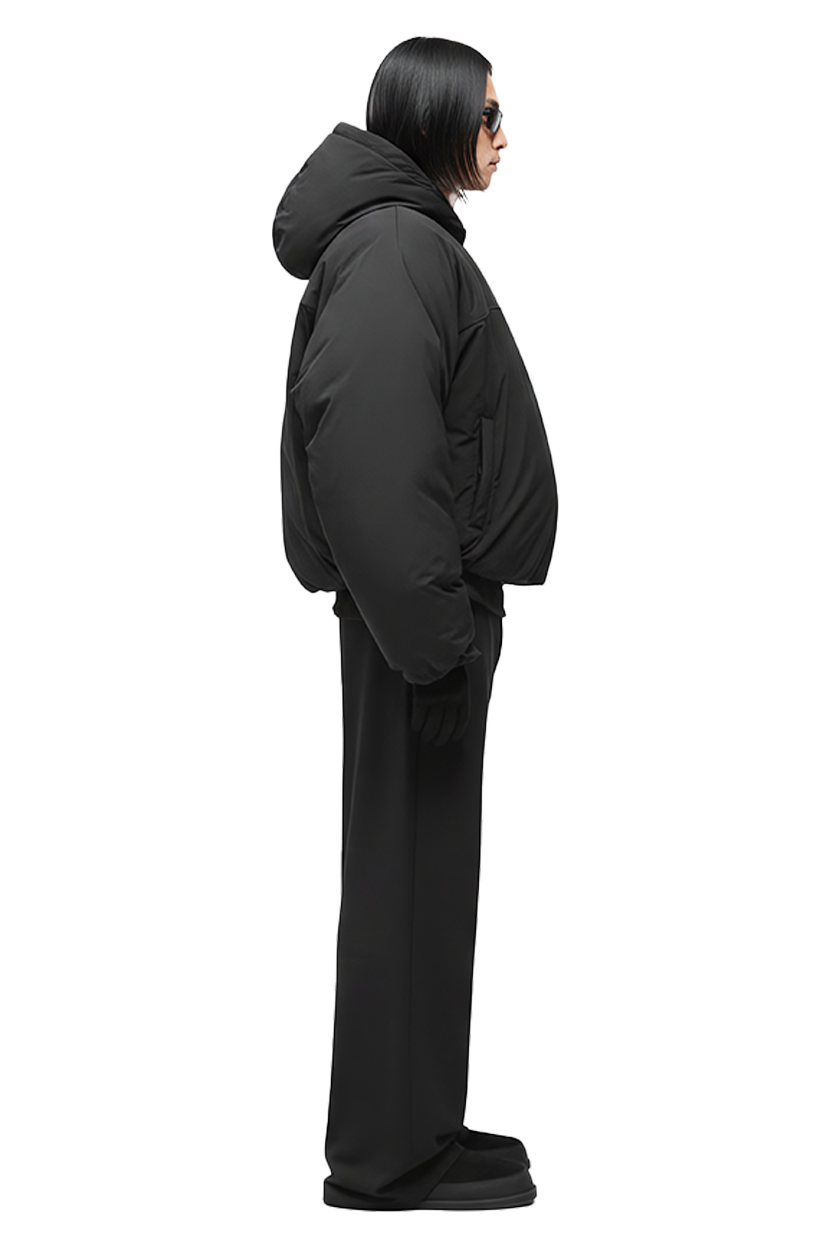 Woman wearing black puffer jacket and pants, side view. Stylish winter look.