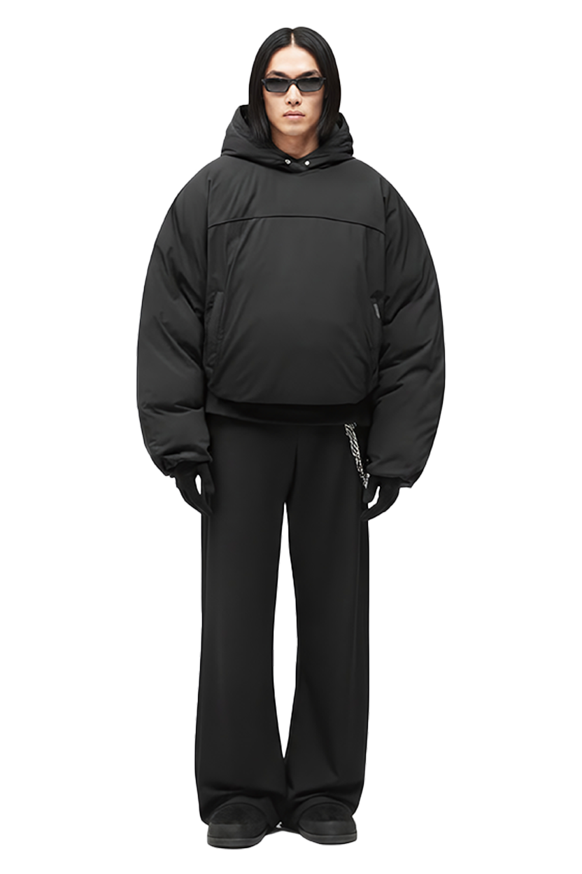 Model wearing black puffer jacket and pants, looking forward in studio shot