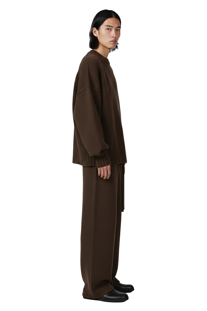 Man in brown sweatshirt and pants, looking to the side confidently.
