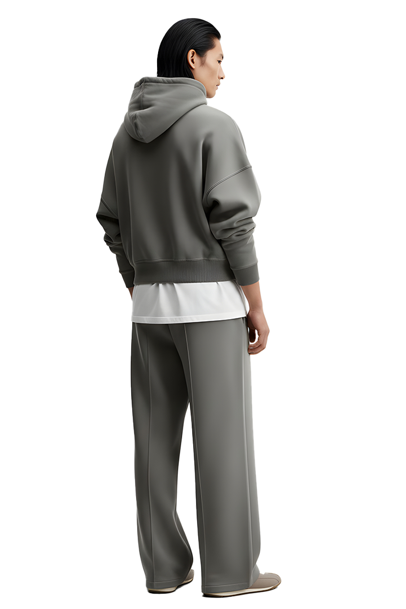 Person wearing gray hoodie, white shirt, and matching pants, standing casually.
