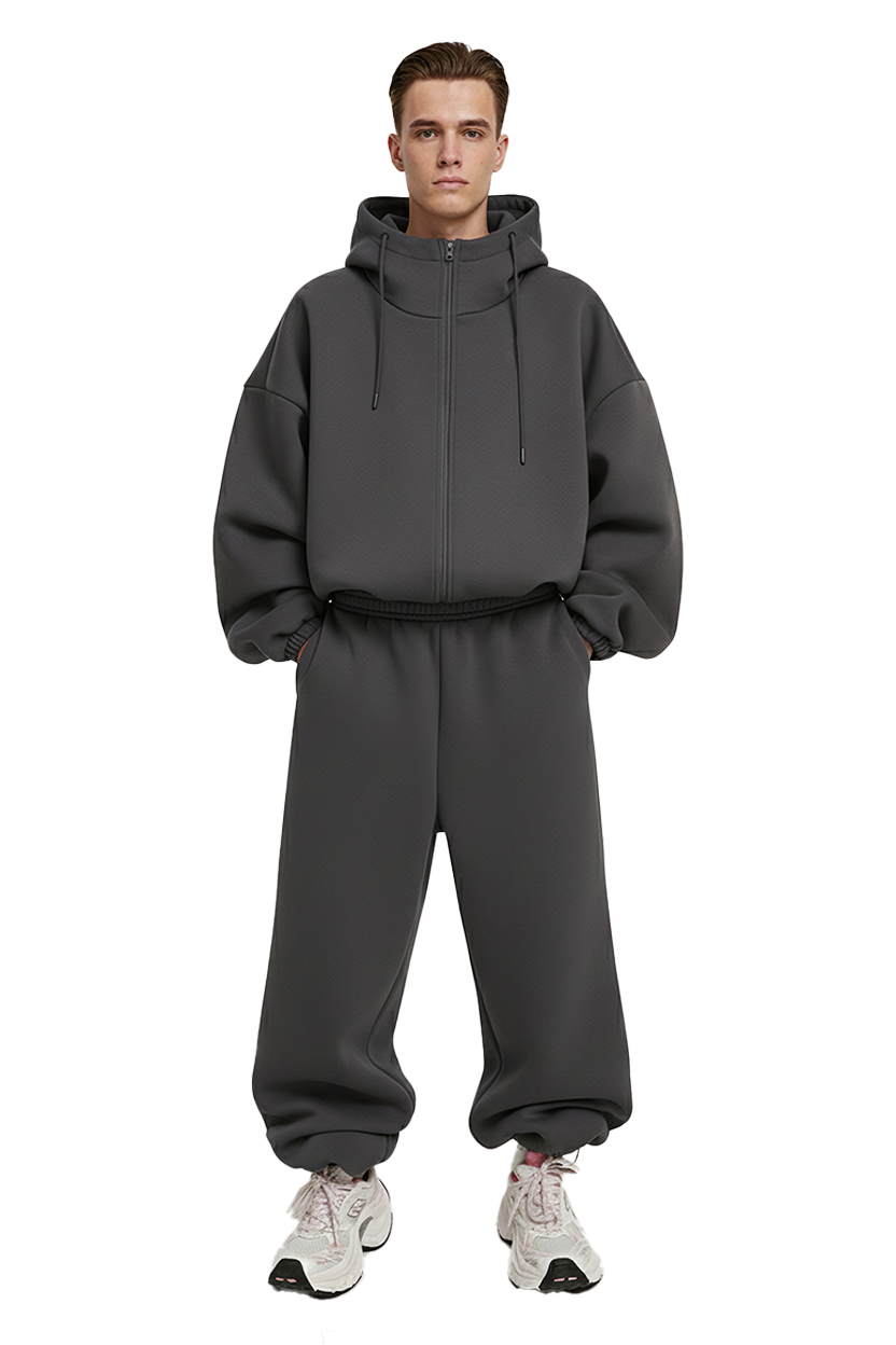 Man wearing dark gray hoodie and sweatpants posing for a photo
