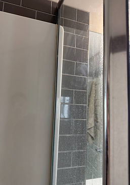 Dirty shower door with soap scum and water stains — before cleaning by Cleanphoria.