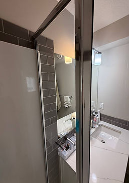Crystal-clear shower door and tiles after professional cleaning by Cleanphoria.