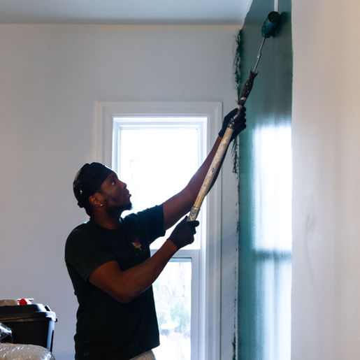 Rolling the first coat of paint onto walls