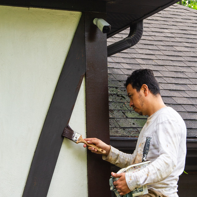 Brushing on solid-stain to exterior wood siding