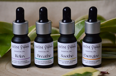 4 flesjes met etherische olie van Arôm Naturales collectie op een kalme botanische achtergrond met natuurlijke elementen