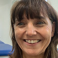 Claire Wright, Chartered Physiotherapist, smiling and wearing clinic uniform, standing in a professional healthcare setting.