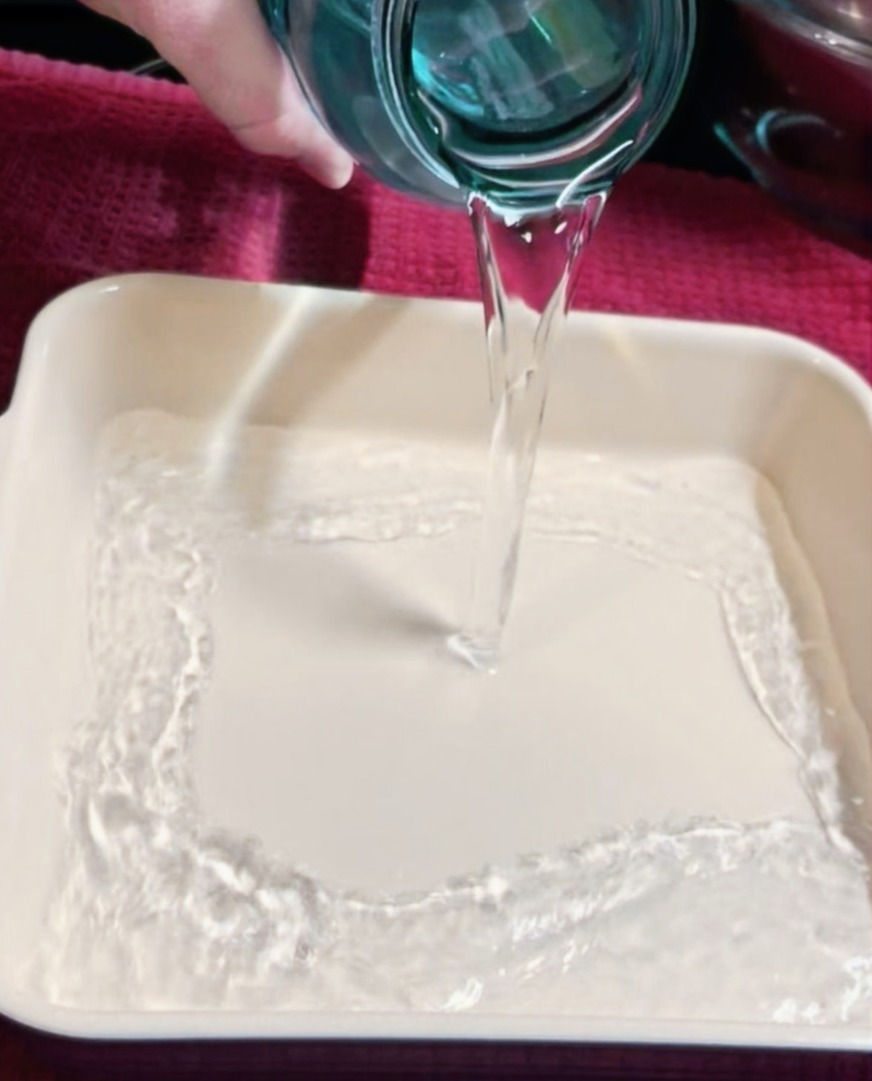 pouring water into an oven safe dish