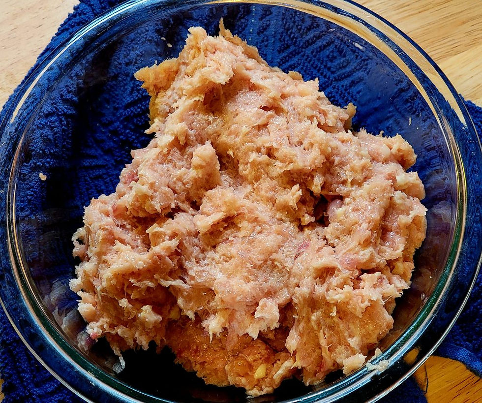 A bowl of chicken thigh meat that has been pulsed in a food processor to resemble ground chicken